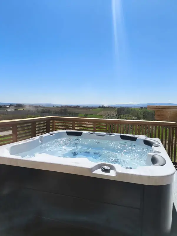 Spa extérieur sur terrasse bois avec vue sur les vignes